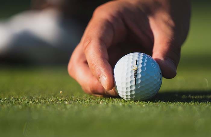 Close up of a hand holding a golf ball