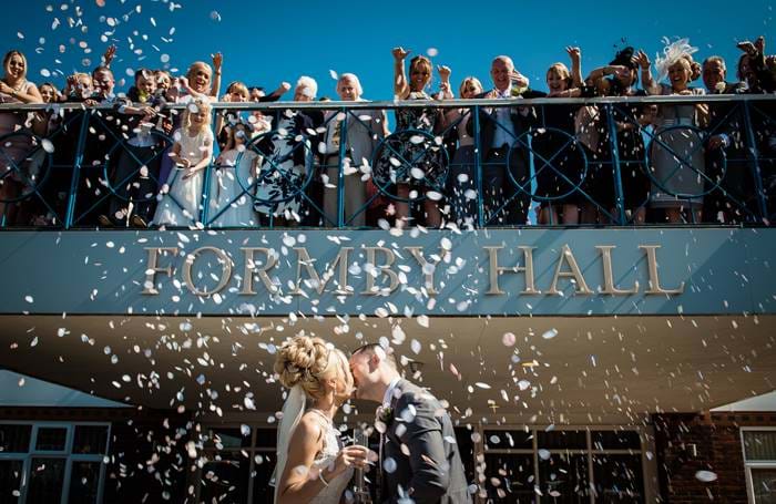 Confetti sprinkled over the bride and groom outside Formby Hall